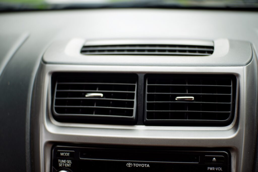 Car air conditioning vents and control panel, highlighting auto AC repair services in Jackson, MI.