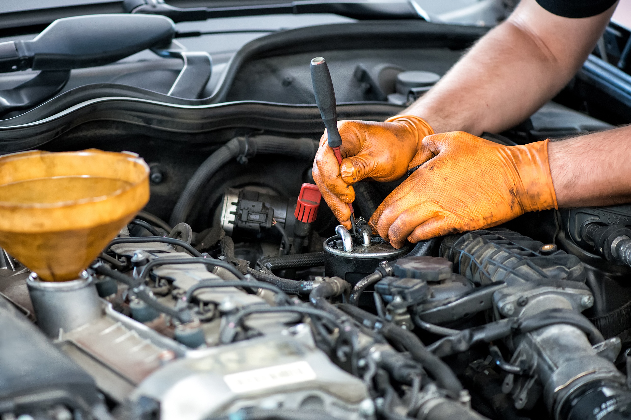 Mechanic performing Powerstroke diesel repair with tools on engine components at MDP Diesel & Auto in Jackson, MI.